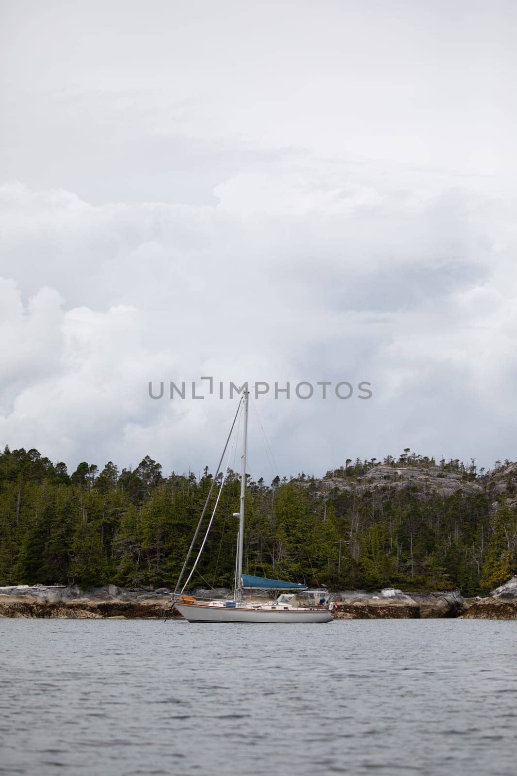 A beautiful sailboat in a remote anchorage with mountains in the background by Granchinho