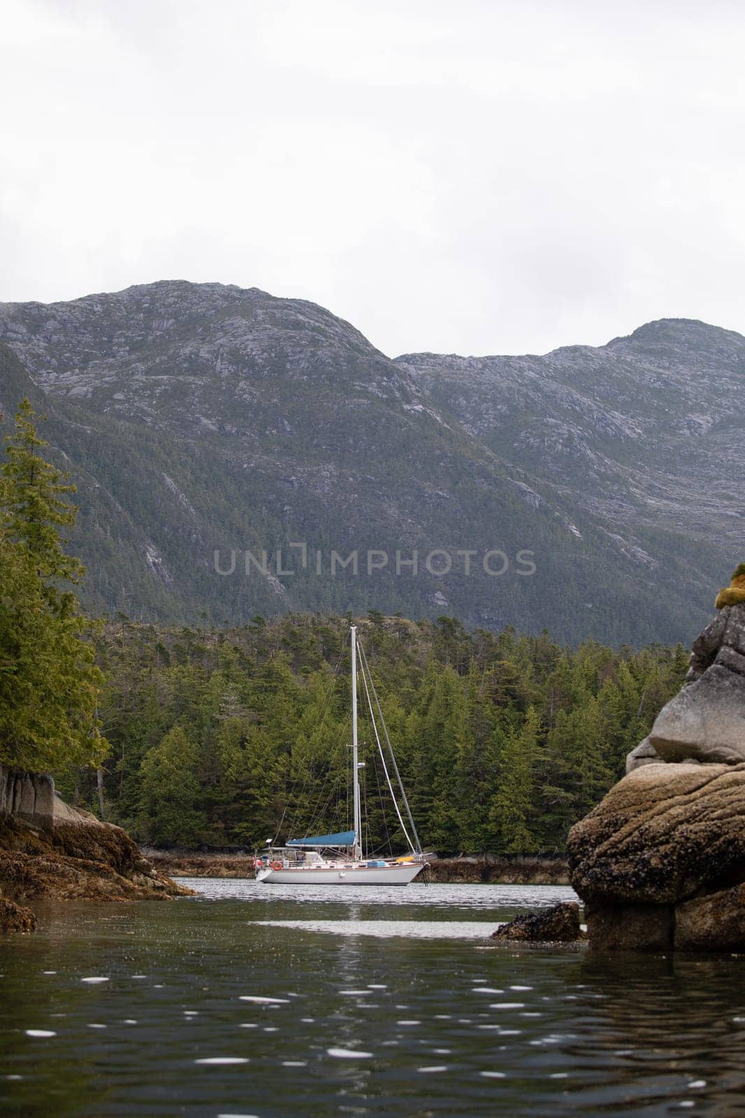 A beautiful sailboat in a remote anchorage with mountains in the background by Granchinho