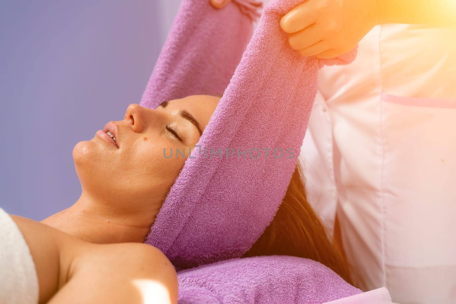 Relaxing massage. European woman getting head massage in spa salon, side view.
