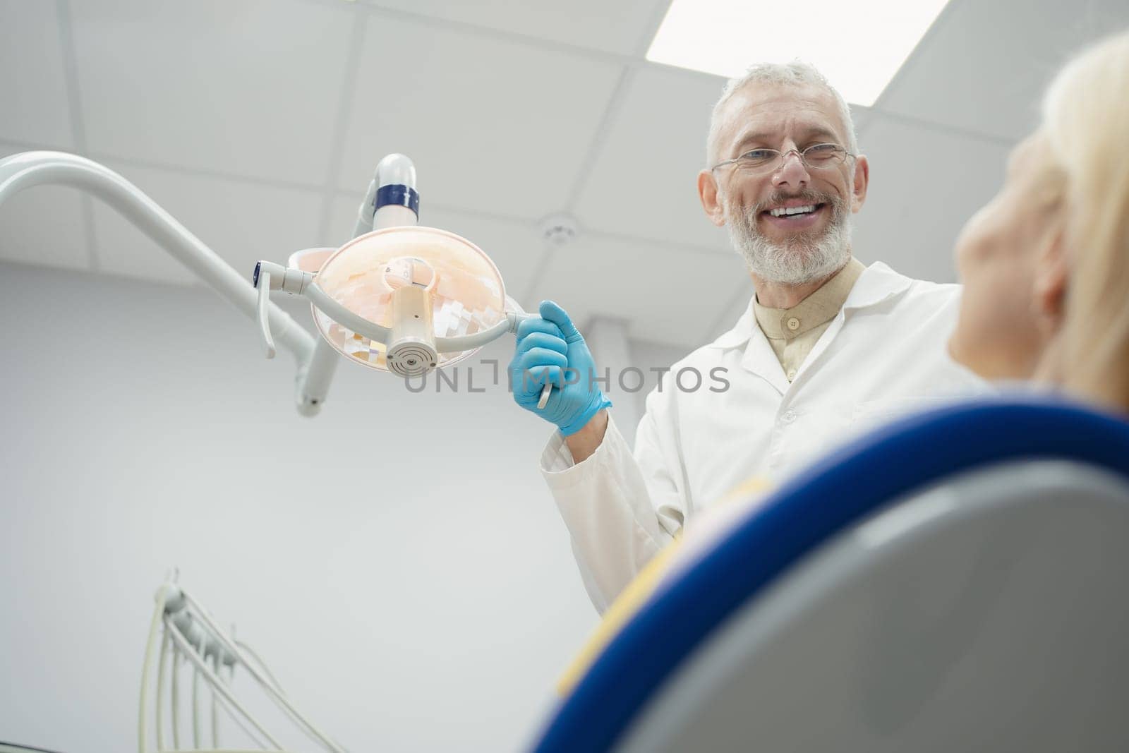 Woman smiling during her dental treatment at dentist.