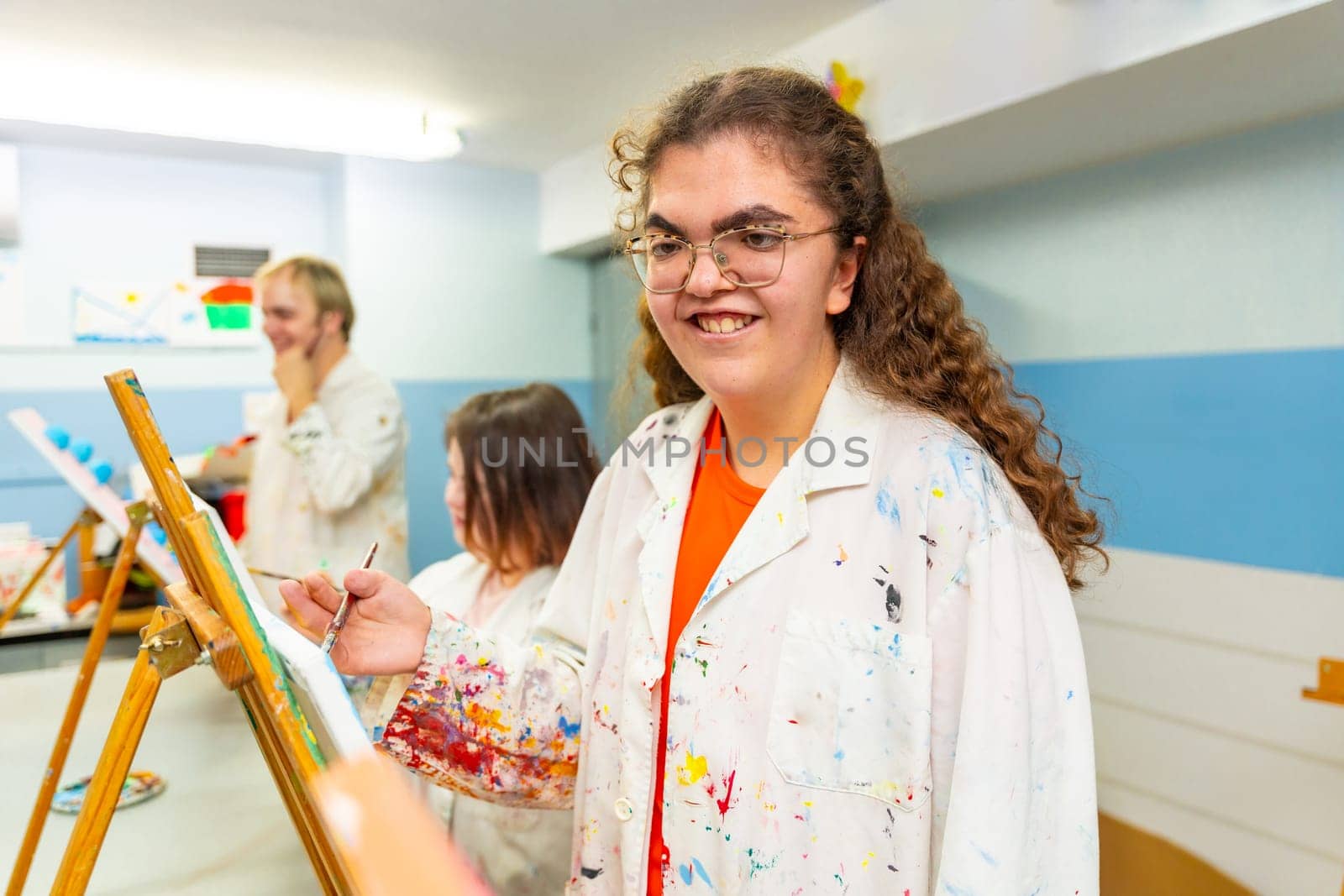 Disabled woman smiling during painting class indoors by Huizi