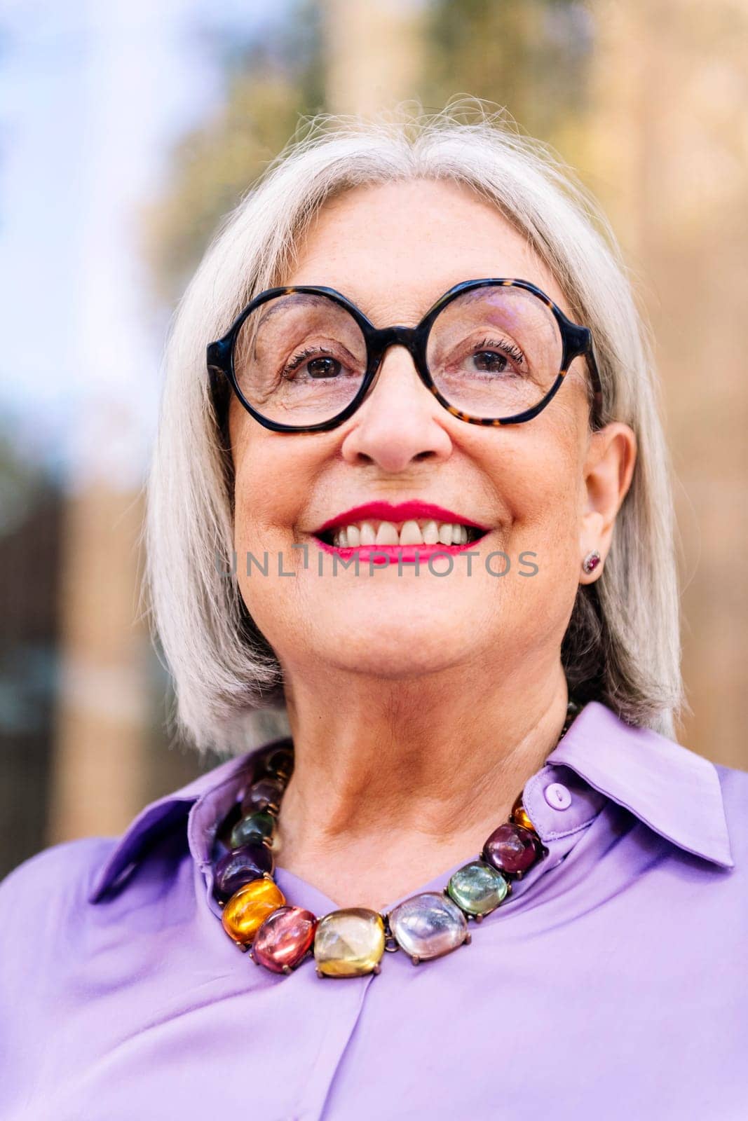 vertical portrait from below of a beautiful senior woman smiling happy, concept of elderly people leisure and active lifestyle