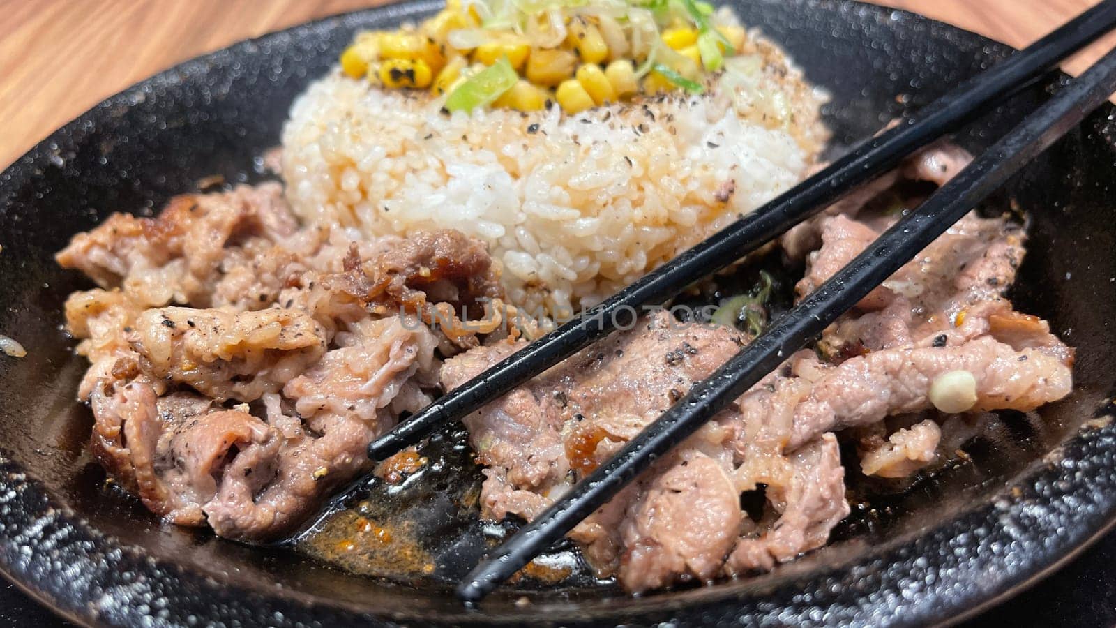 selective focus grilled beef steak with korean sauce bulgogi on top of rice with slice of pepper and sweet corn - korean and japanese food style in a restaurant