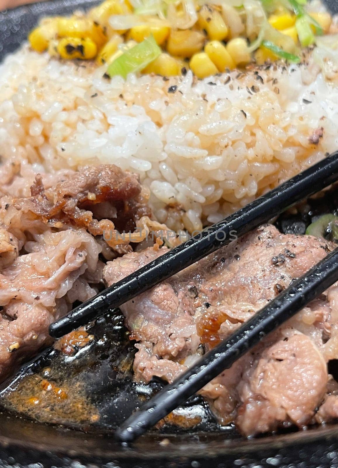 selective focus grilled beef steak with korean sauce bulgogi on top of rice with slice of pepper and sweet corn - korean and japanese food style in a restaurant