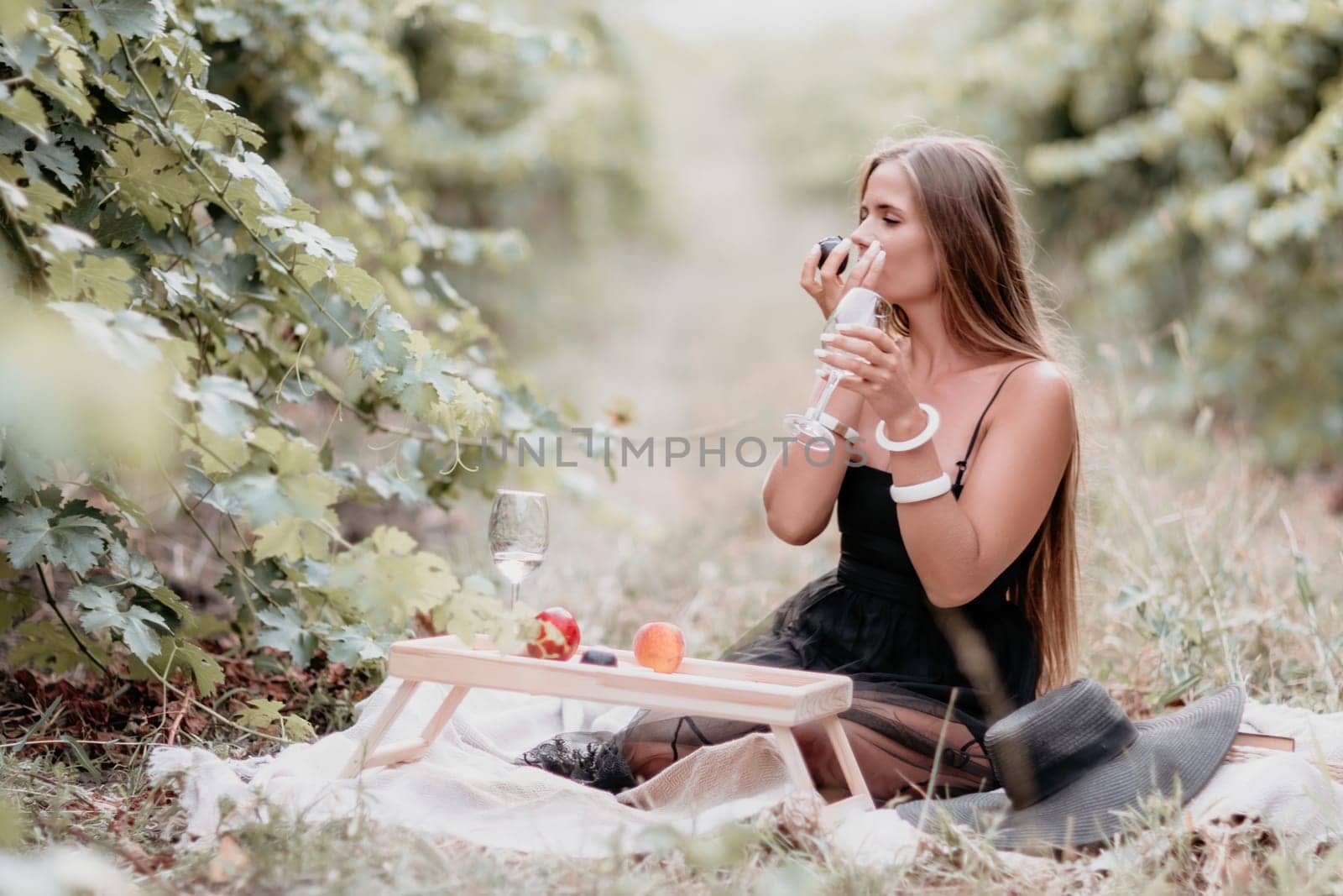 Picnic and wine tasting at sunset in the hills of Italy, Tuscany. Vineyards and open nature in the summer. Romantic dinner, fruit and wine.