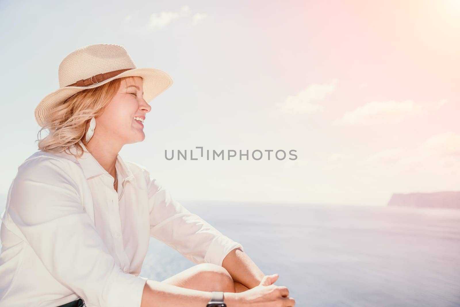 Woman sea laptop. Business woman in yellow hat freelancer with laptop working over blue sea beach. Girl relieves stress from work. Freelance, digital nomad, travel and holidays concept by panophotograph