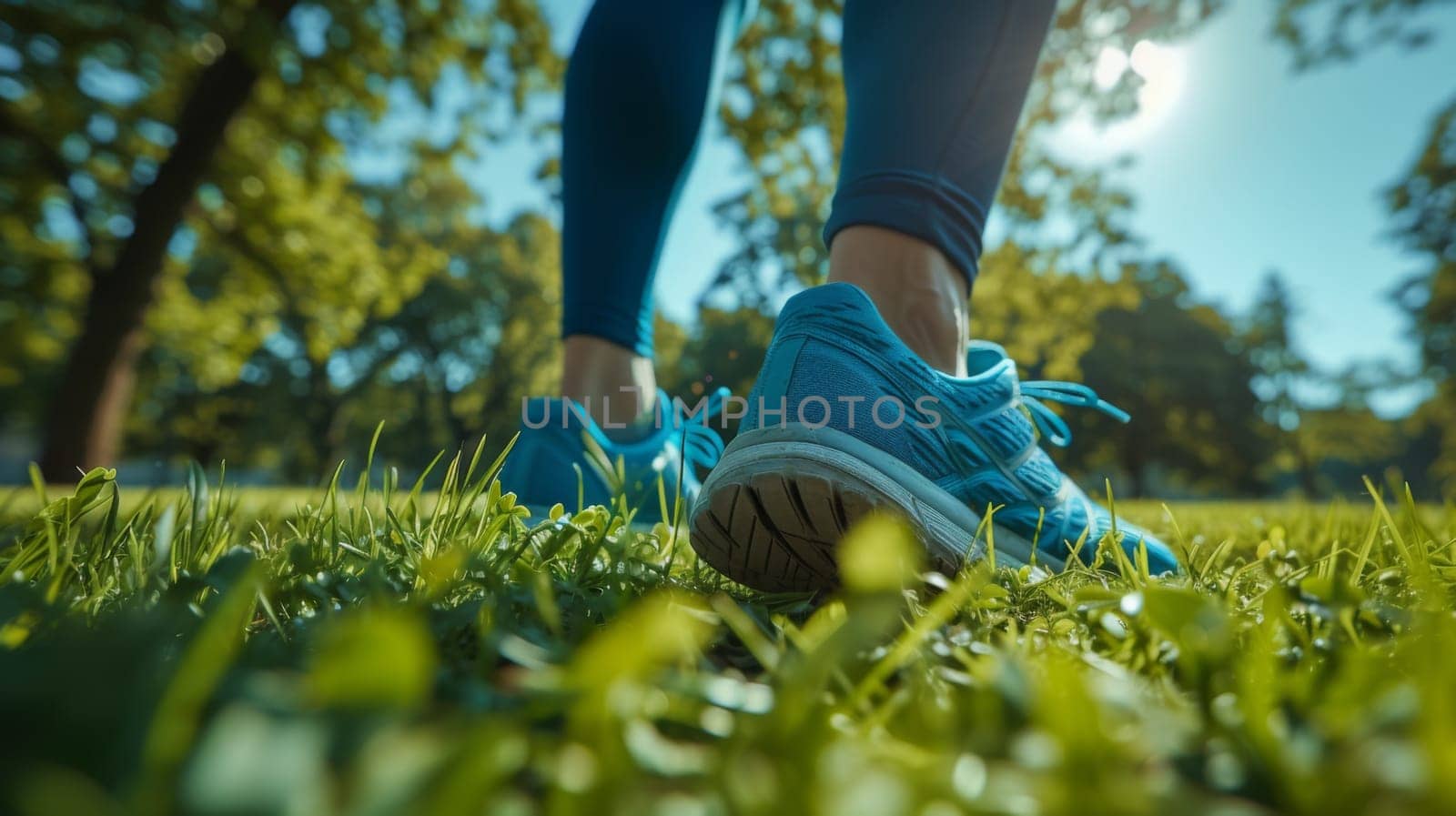 A person wearing blue shoes walking through a grassy field