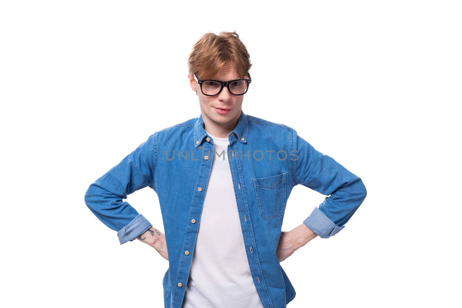 portrait of a slender handsome european red-haired student guy dressed in a denim shirt and glasses on a white background by TRMK