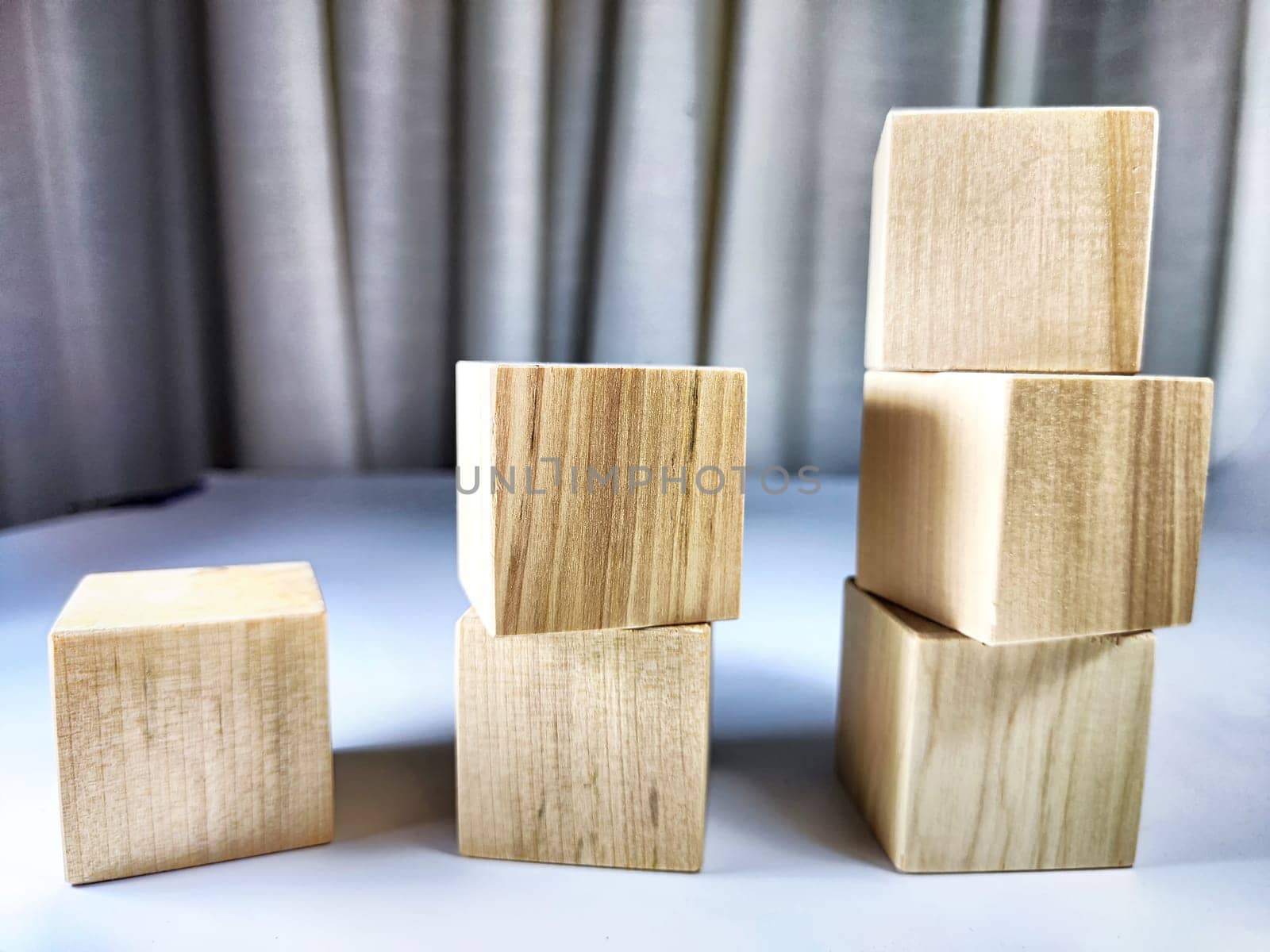 Small wooden cubes in columns, lined up in a row. The concept of progressive movement in achieving the goal. Steps and stages of project development and implementation