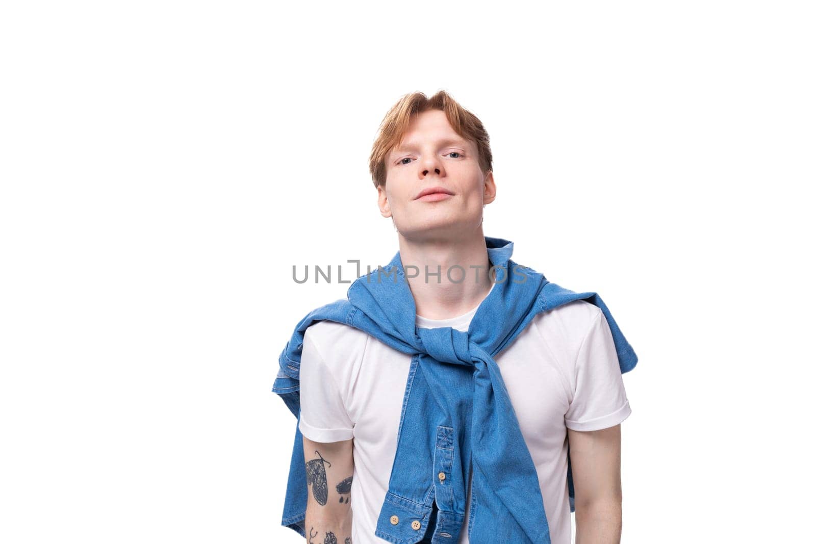 portrait of a young stylish fashionable european man with red hair and a tattoo on his arms on a studio background. people lifestyle concept by TRMK