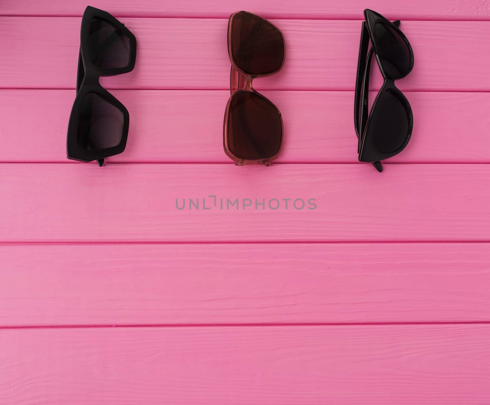 Summer abstract background mockup template free copy space for text pattern sample top view above on pink wooden board. blank empty area for inscription. Couple Stylish black sunglasses fashionable