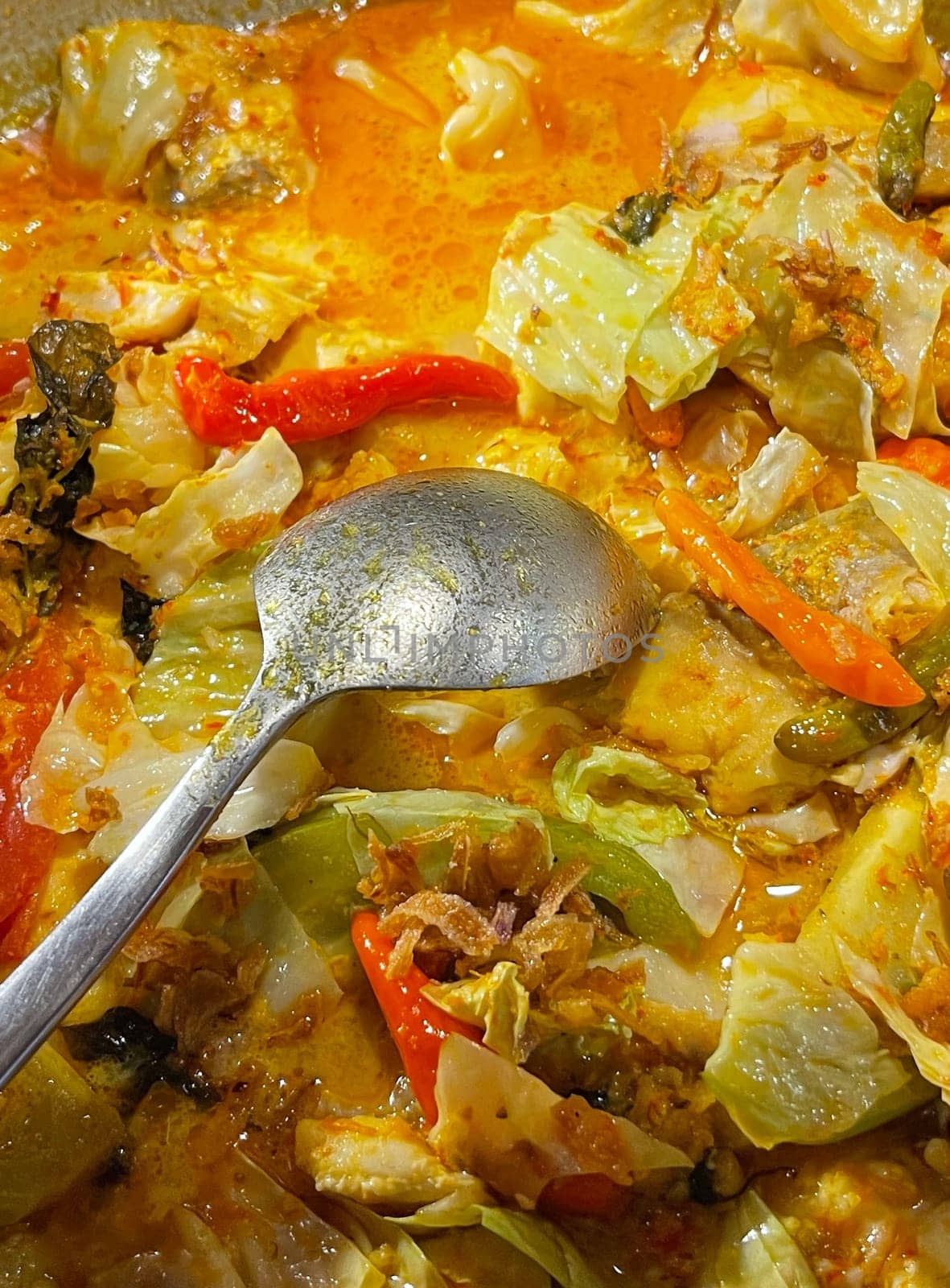 Selective focus Indonesian traditional dish mangut fish, made from smoked fish, cooked with coconut milk sauce mixed with spices, tomato, turmeric, and chillies with various seasonings