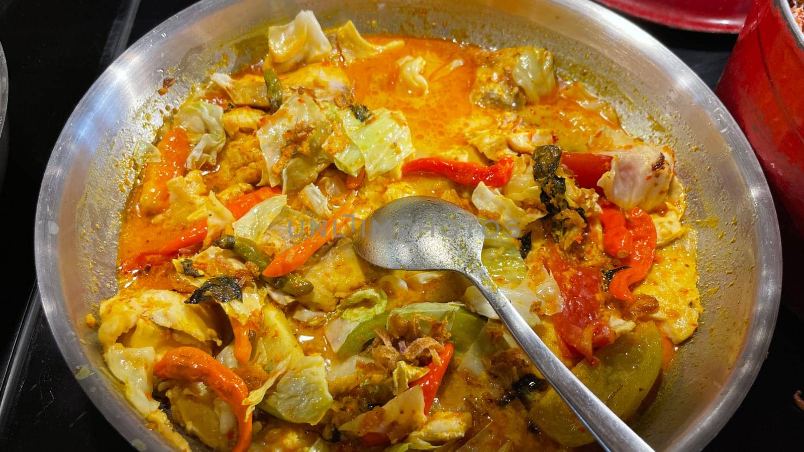 Selective focus Indonesian traditional dish mangut fish, made from smoked fish, cooked with coconut milk sauce mixed with spices, tomato, turmeric, and chillies with various seasonings
