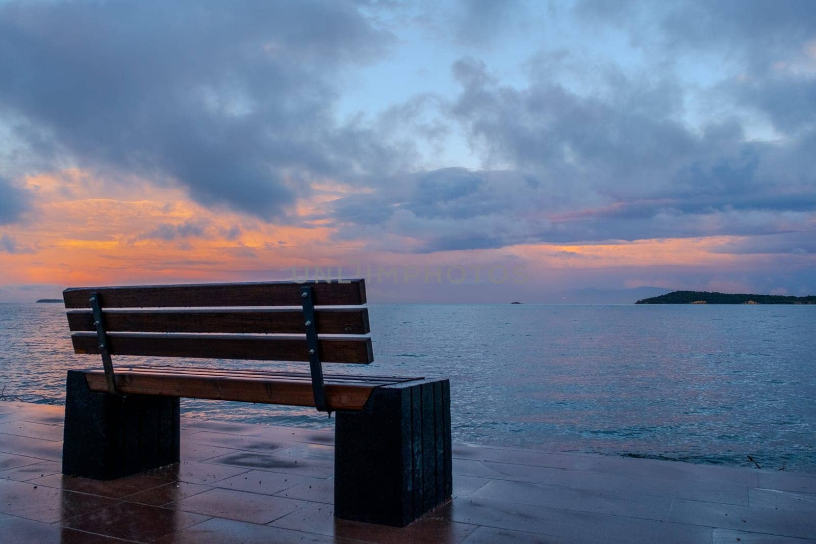 Wooden bench on dock by water at sunset, overlooking ocean by senkaya