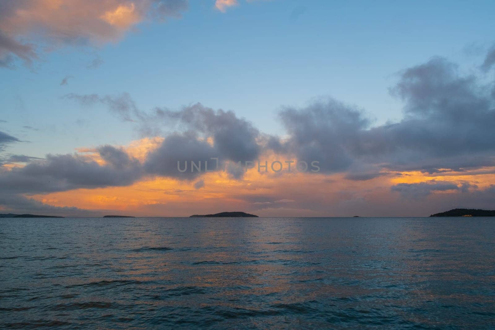 Blurred image of sunset over water, with cloudy sky and afterglow by senkaya