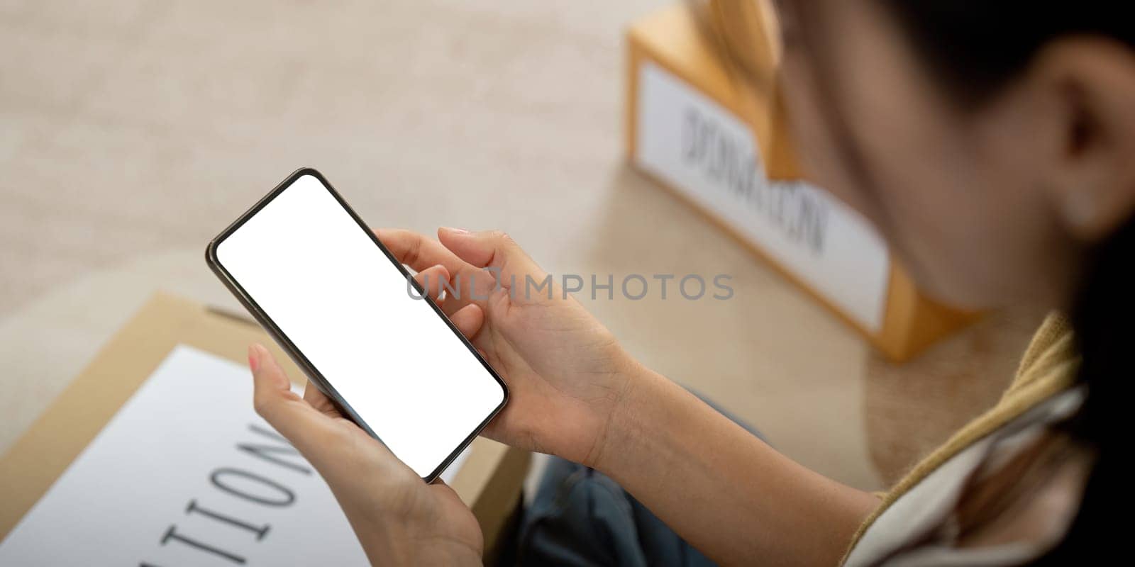 Mockup of a woman holding and using mobile phone with blank screen while laying down on the floor with feel relax by nateemee