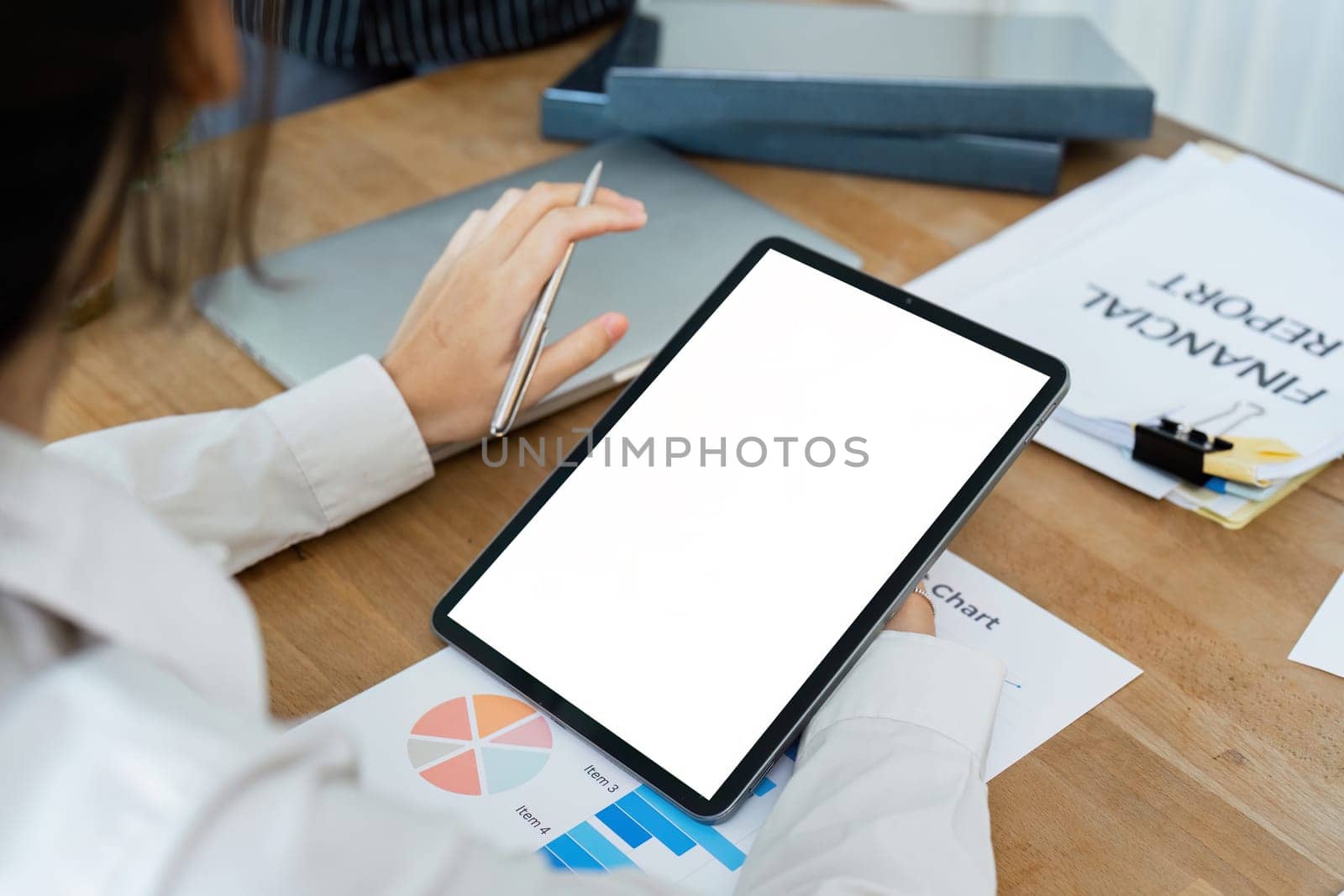 Businesswoman talks to colleague about strategy on tablet while meeting by itchaznong