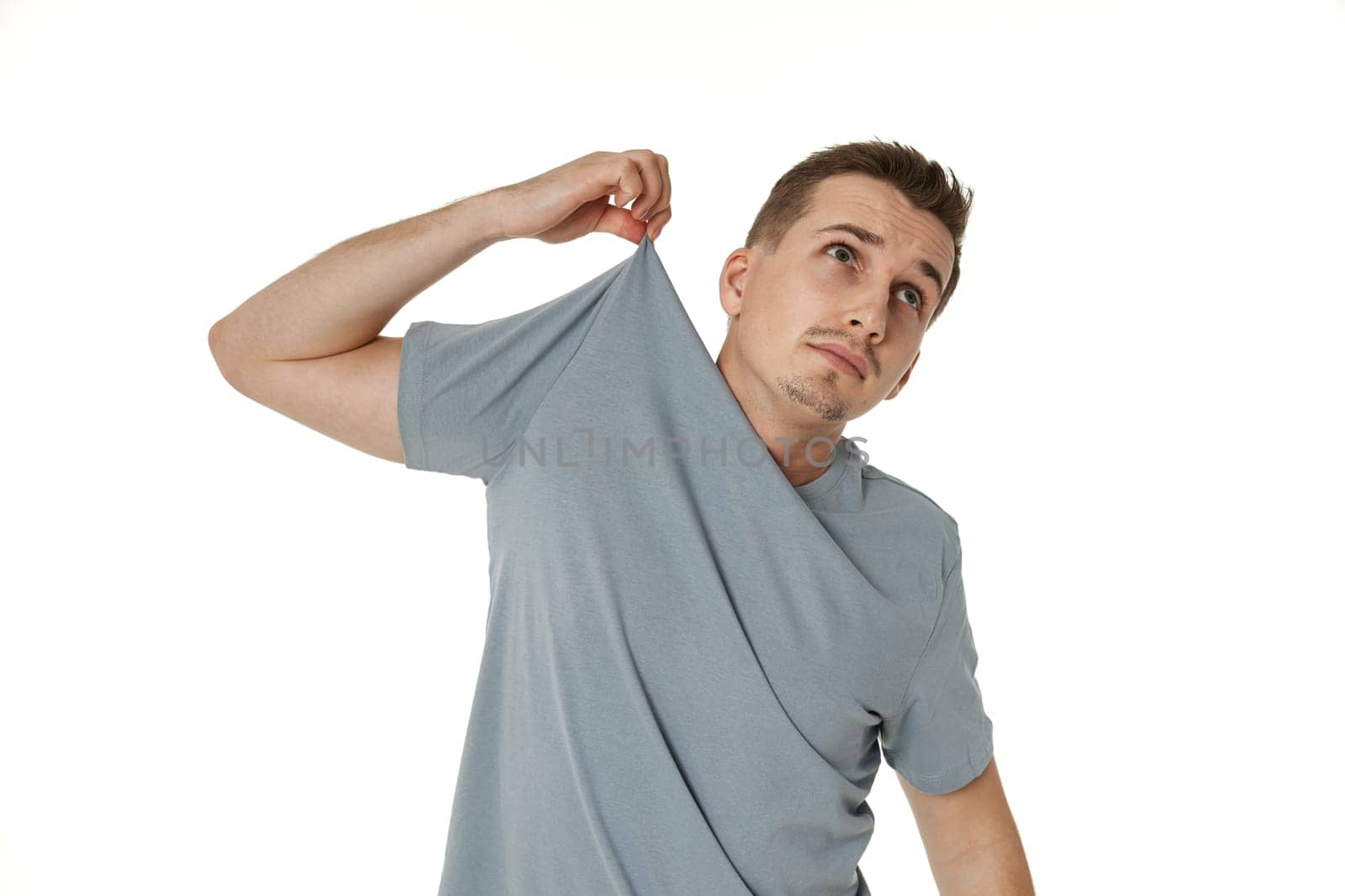 man holding himself by the shoulders on white background by erstudio