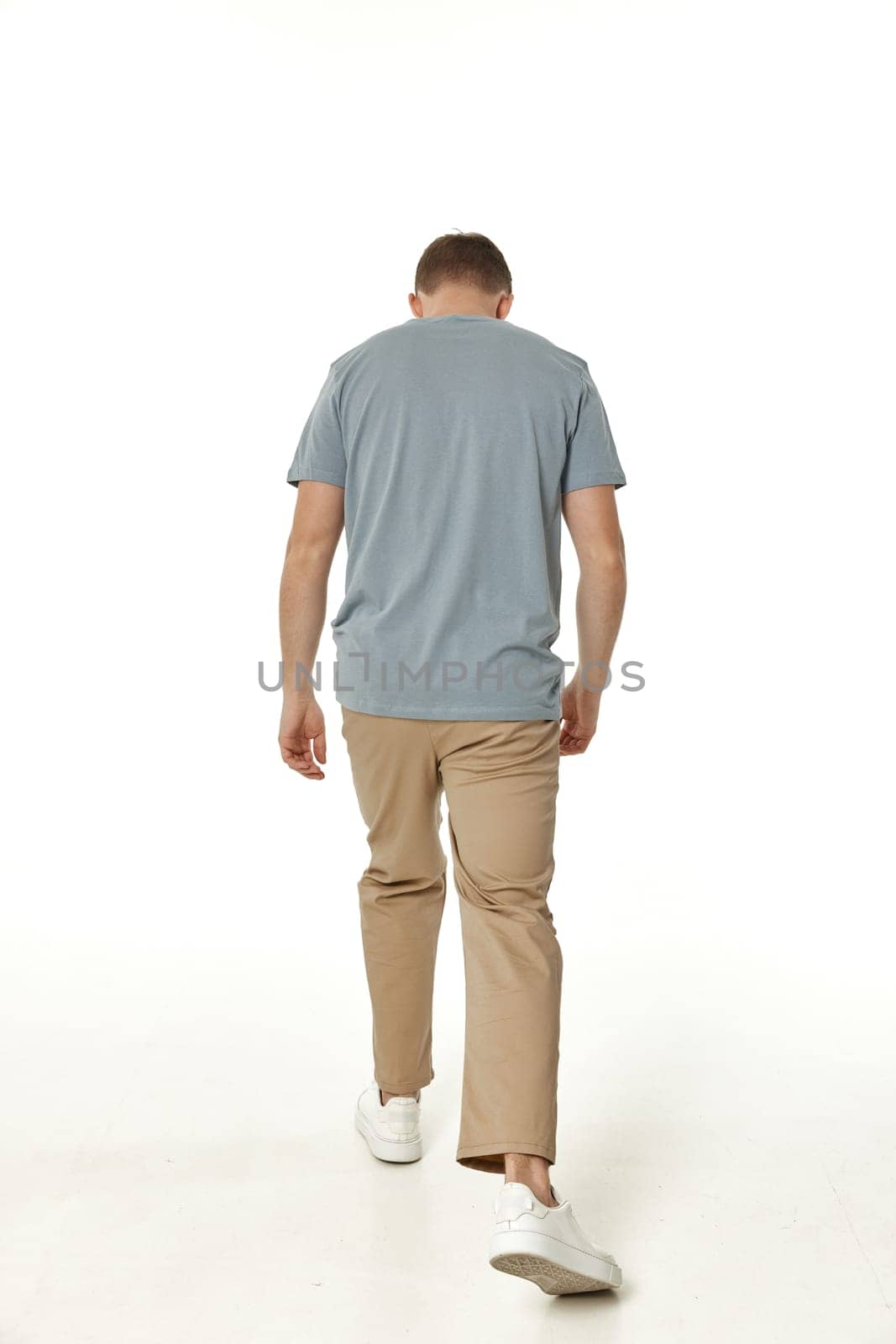 young man on white background, rear view