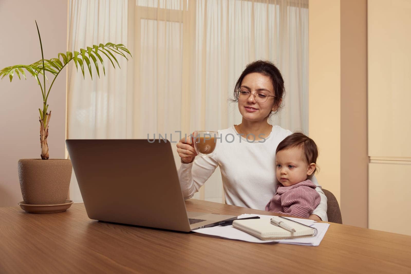 businesswoman working at home with her little child girl by erstudio