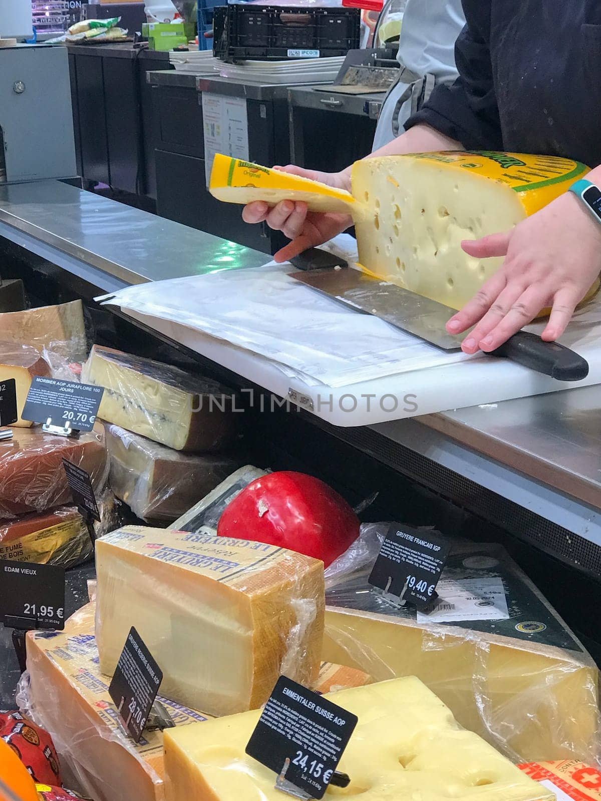 Bordeaux, France, February 9, 2024: Pieces of different cheeses in fridge in supermarket. High quality photo