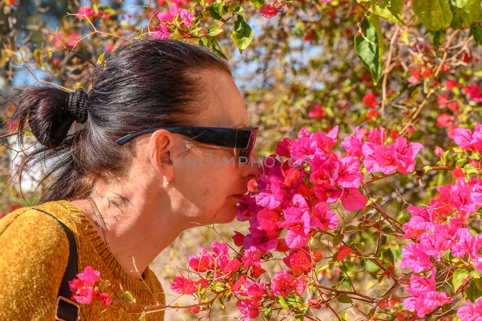 woman smelling bougainvillea flowers in cyprus 1