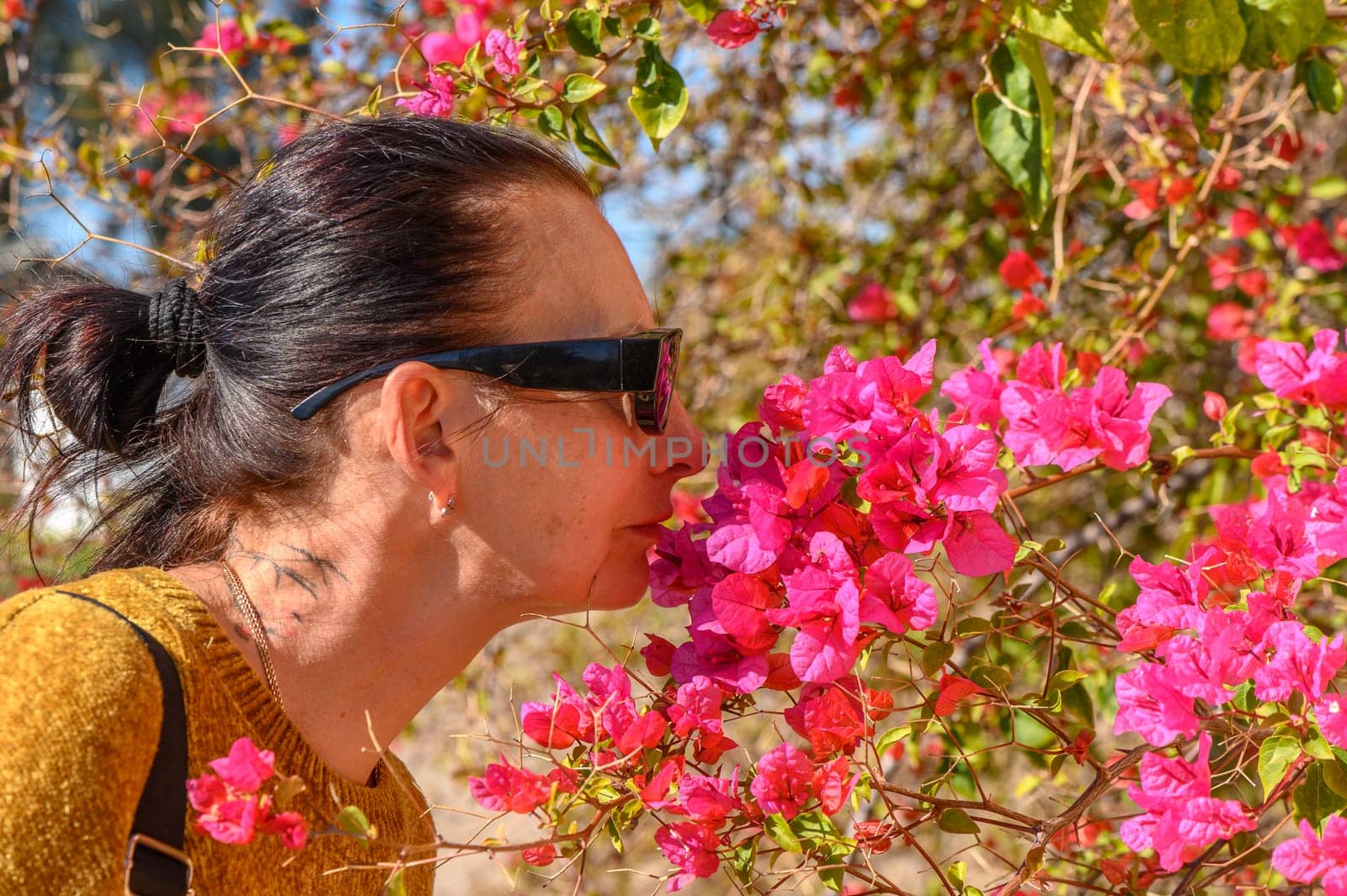 woman smelling bougainvillea flowers in cyprus 3