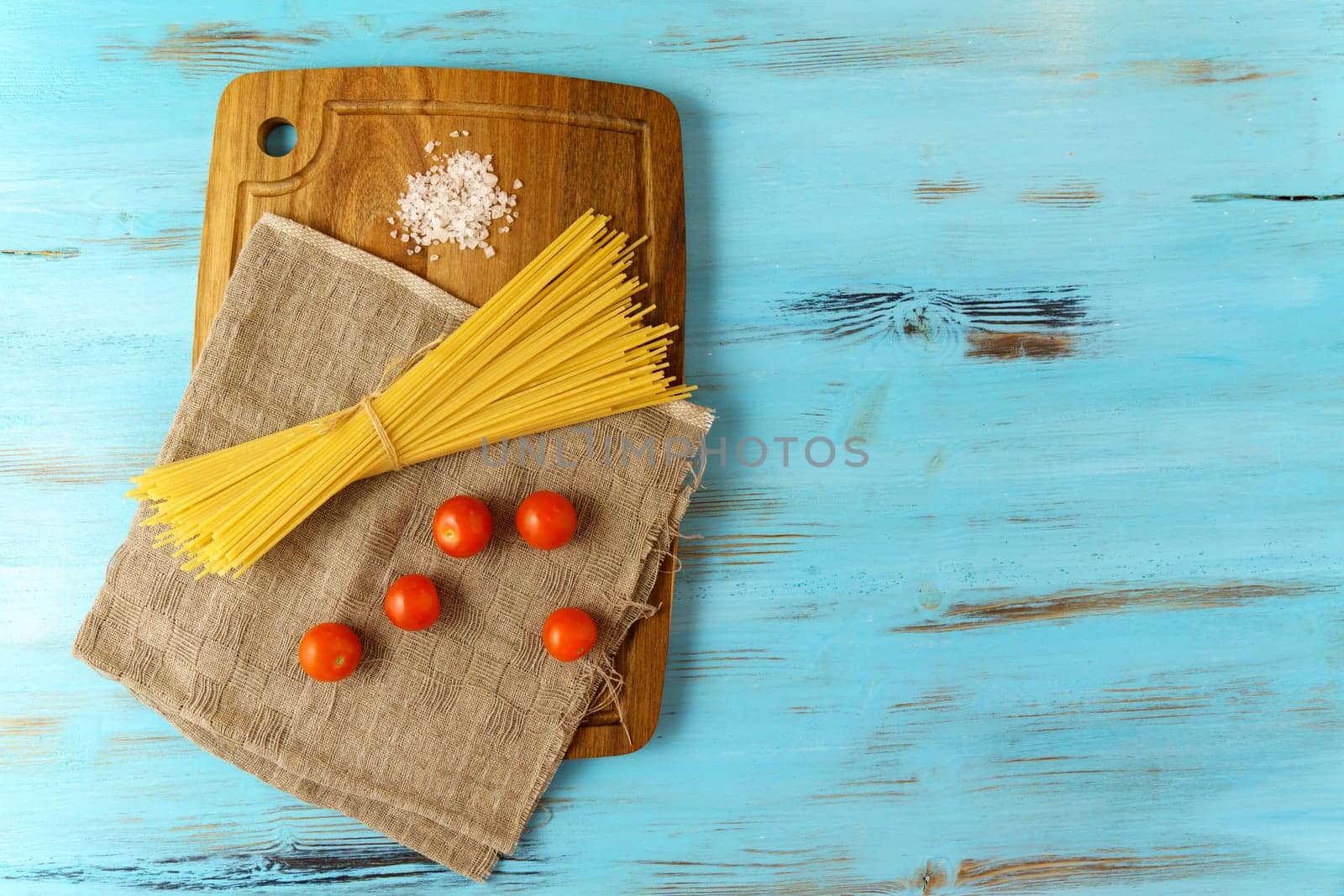 Italian Spaghetti pasta raw food blue background. Copy space by darksoul72