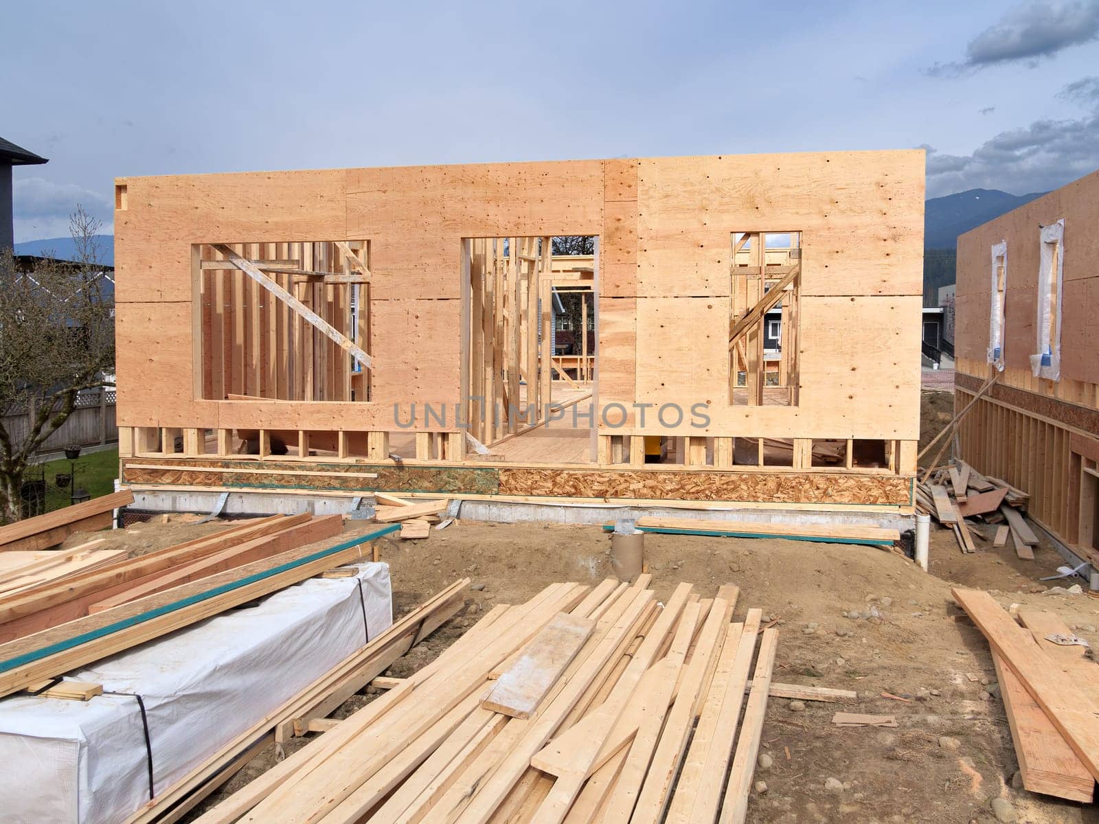 Wooden frame of a new house with engineered lumber materials prepared for the construction. Two by four lumber wood