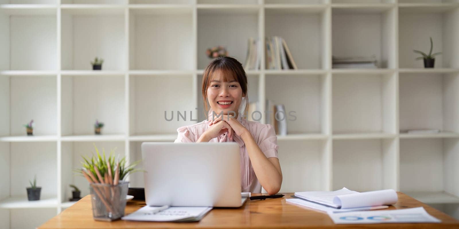 Successful businesswoman inside office at workplace, worker smile and looking at camera with laptop businesswoman is satisfied with results of achievement at work.