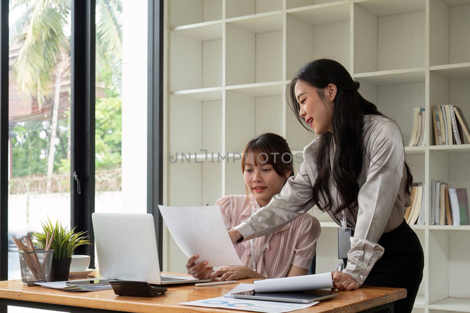 Two businesswoman discussing partner discussing project on laptop in office. Two colleague of professional business people working together at workspace.