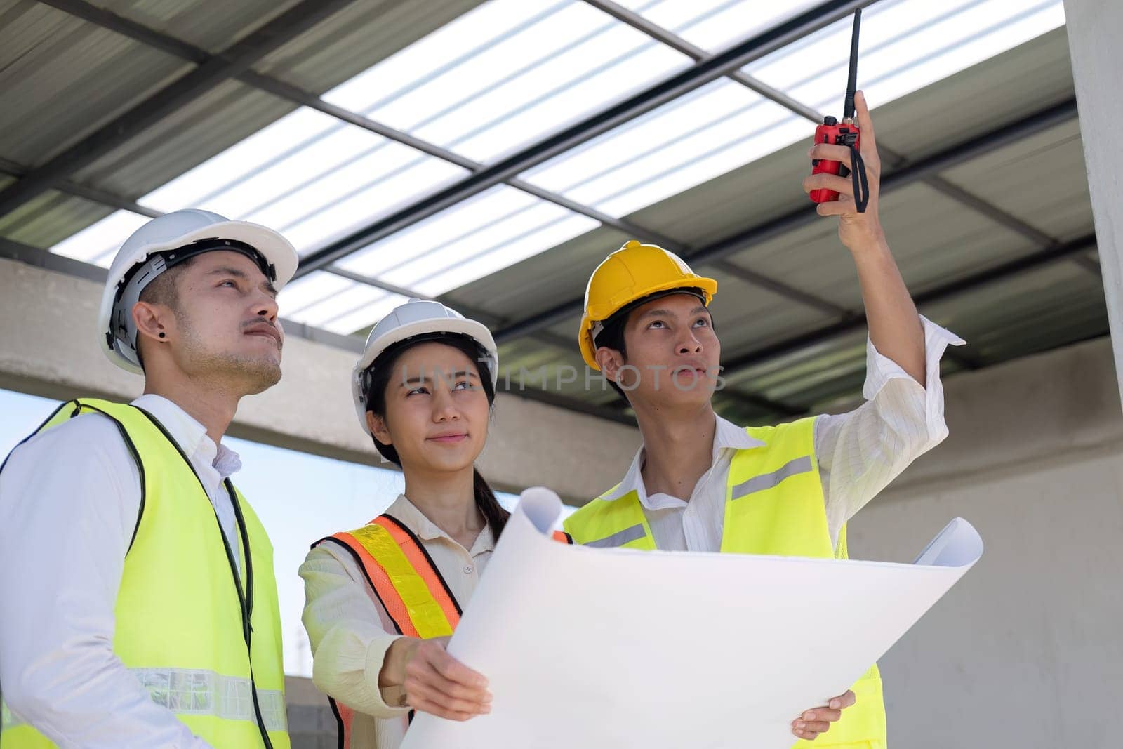 Civil engineer teams meeting working together wear worker helmets hardhat on construction site in modern city. Foreman industry project manager engineer teamwork. Asian industry professional team.