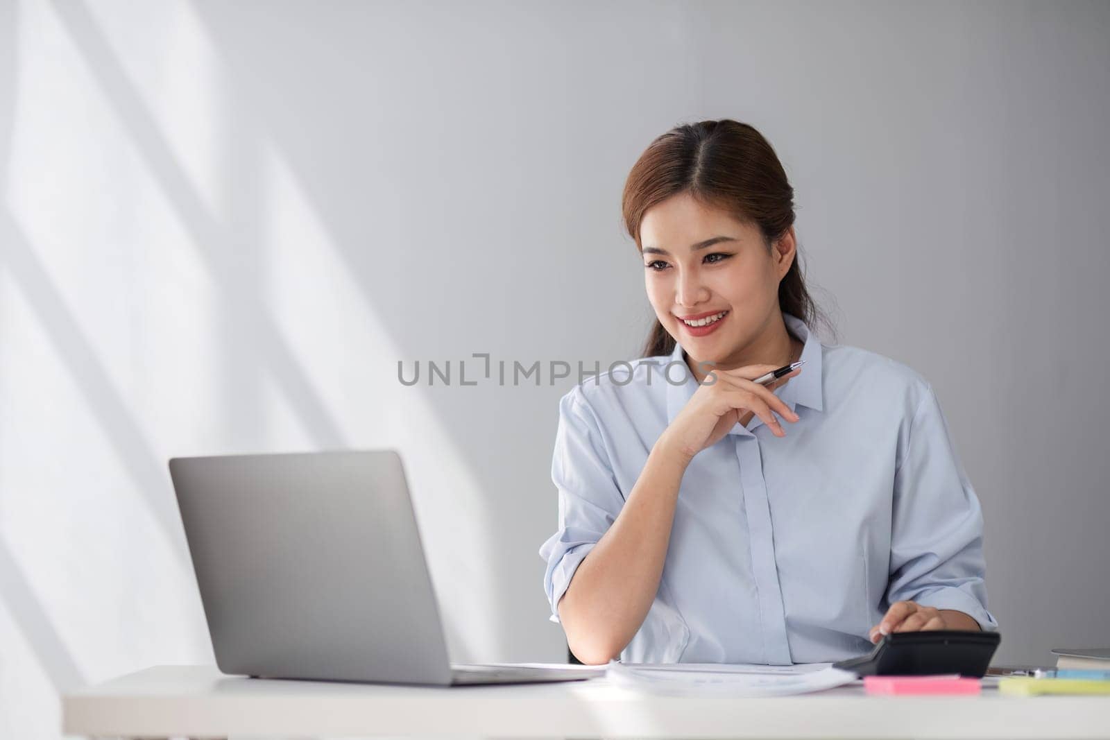 Happy middle-aged businesswoman working in the office. Businesswoman working on laptop and using in remote online job interview meeting on laptop..