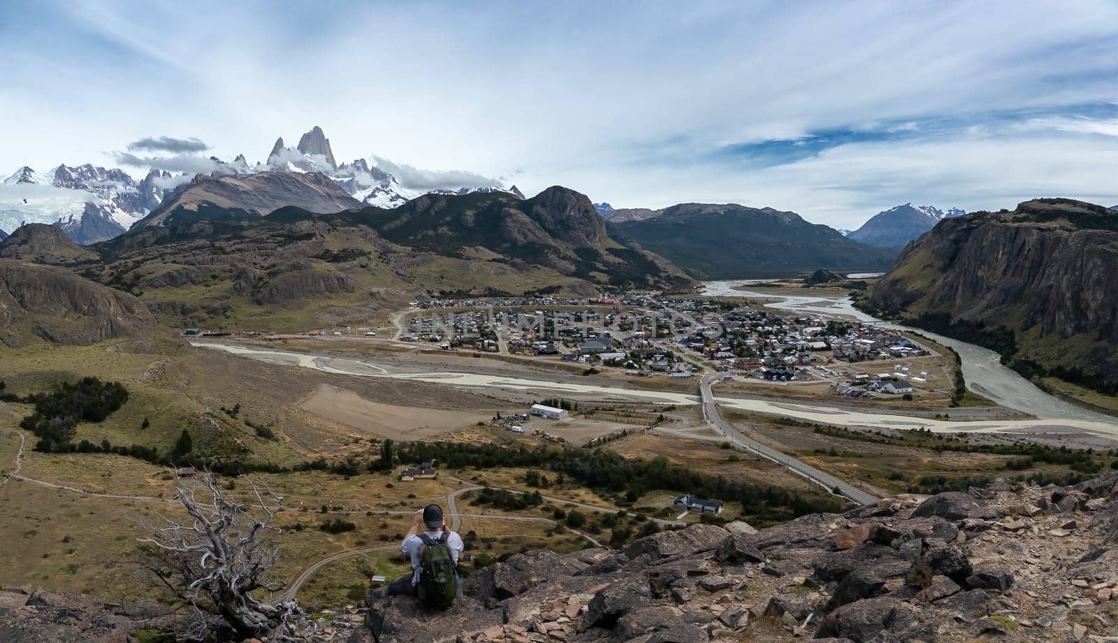 Hiker Overlooking a Scenic Mountain Town in Patagonia by FerradalFCG