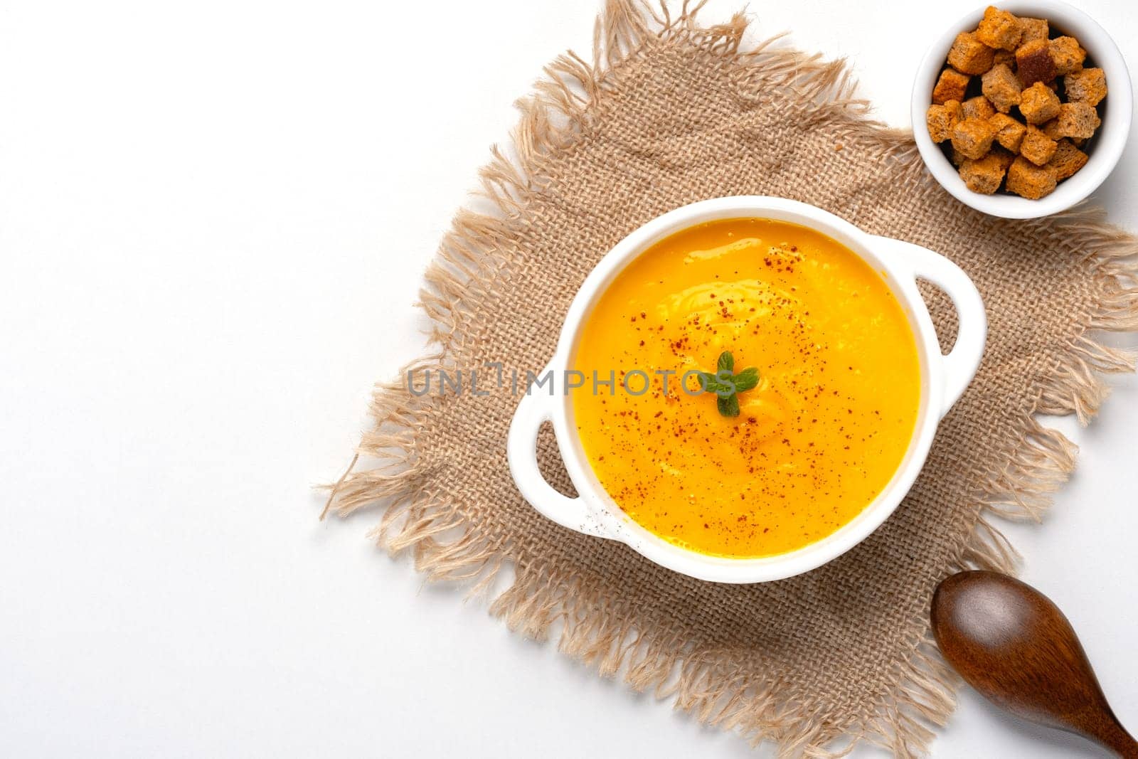 Pumpkin soup with croutons on white background, with copy space for text by NataliPopova