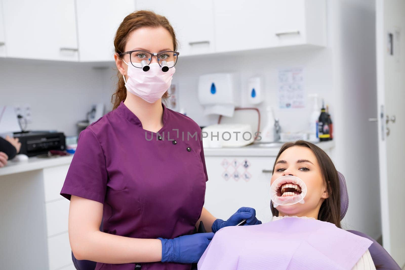 Young female doctor and patient in modern dental clinic by vladimka