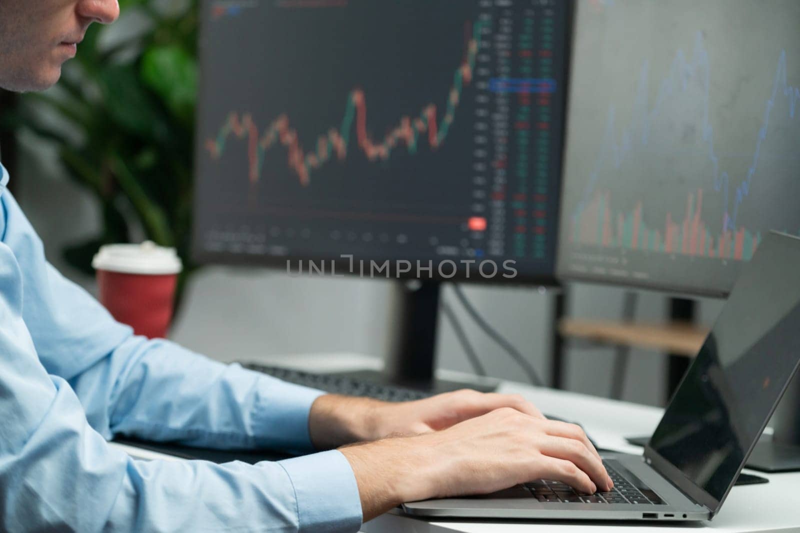 Working young business trader focusing on market stock graph data investment in real time laptop in monitor screens. at modern office. Concept of analyzing dynamic financial exchange rate. Gusher.