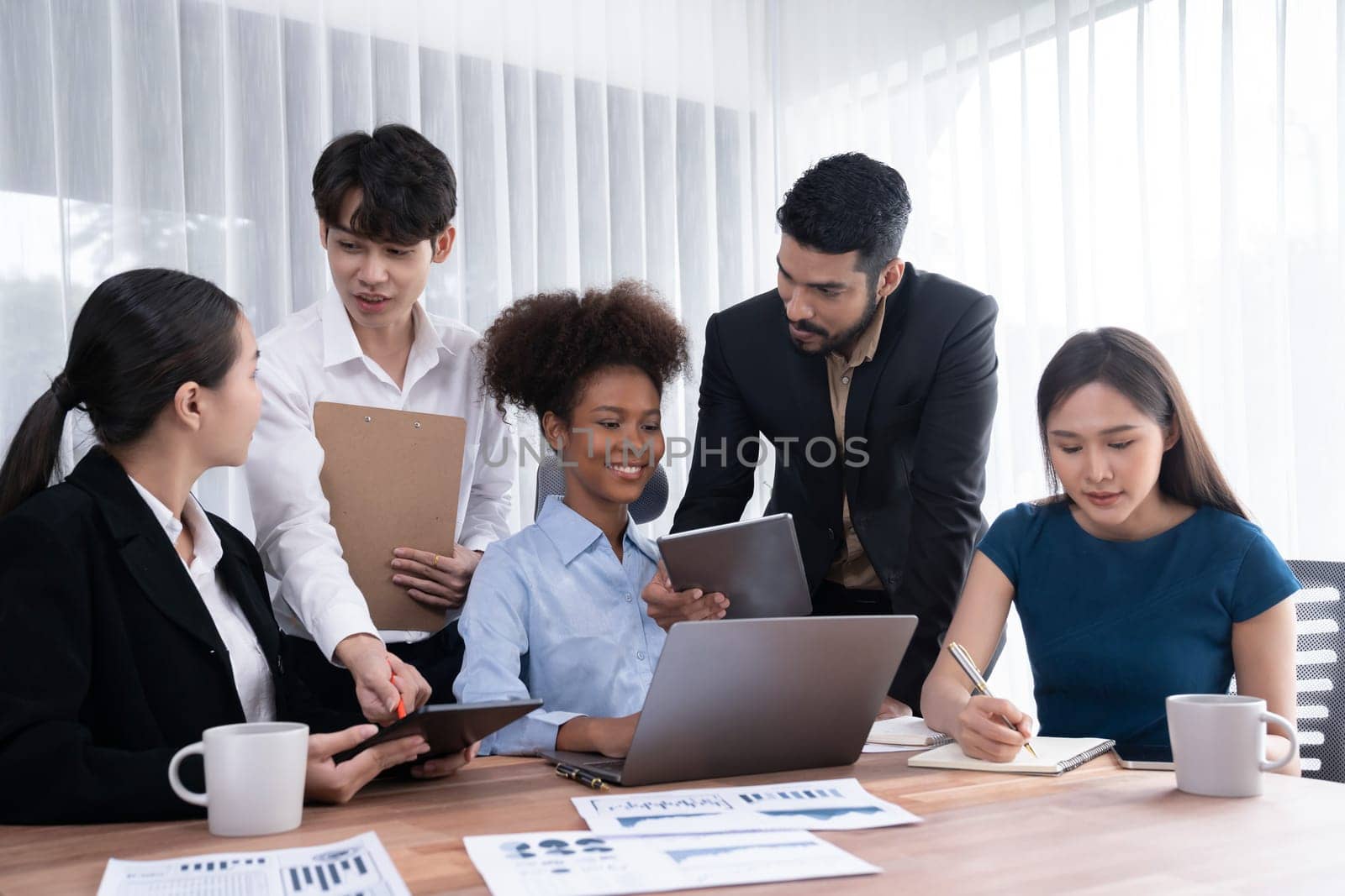 Multiracial analyst team use BI dashboard data to analyze financial report on meeting table. Group of diverse business people utilize data analysis by FIntech for success business marketing. Concord