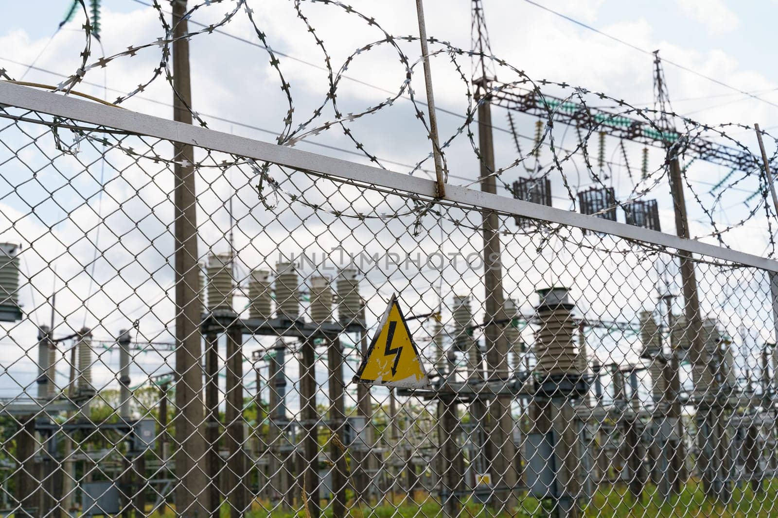 An electrical substation topped with many wires for security and containment purposes.