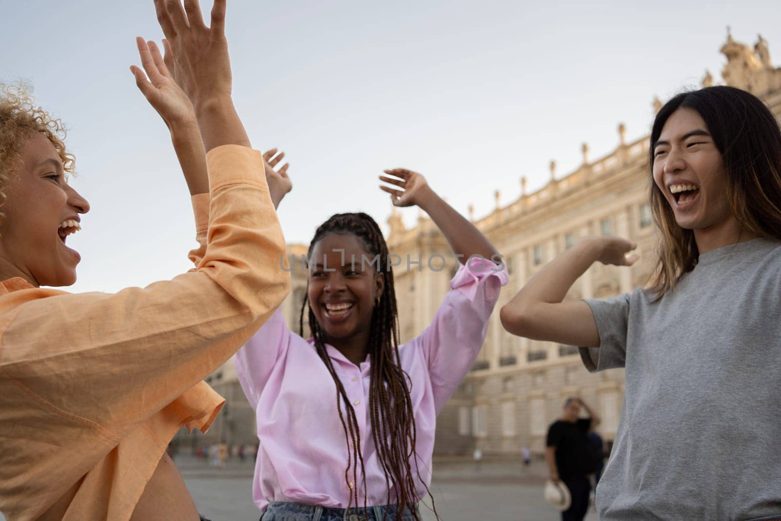 Group of young multiethnic people with raised Hands to the Sky to work as a team and support each other.