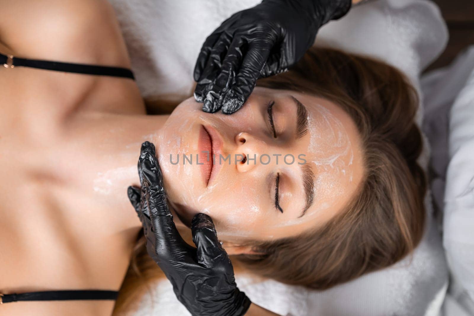 Portrait of a young woman undergoes face massage in a beauty salon.