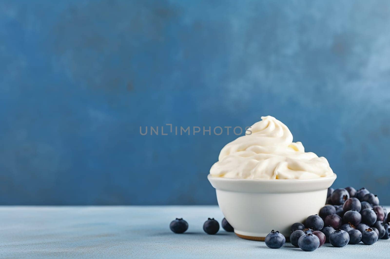 A blueberry yogurt ice cream in a white bowl surrounded by fresh blueberries.