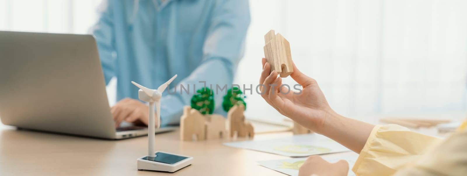 Businesswoman decides to Invest in green business. Skilled architects plan to build a eco house by using renewable energy at table with environmental document scatter around. Close up. Delineation.