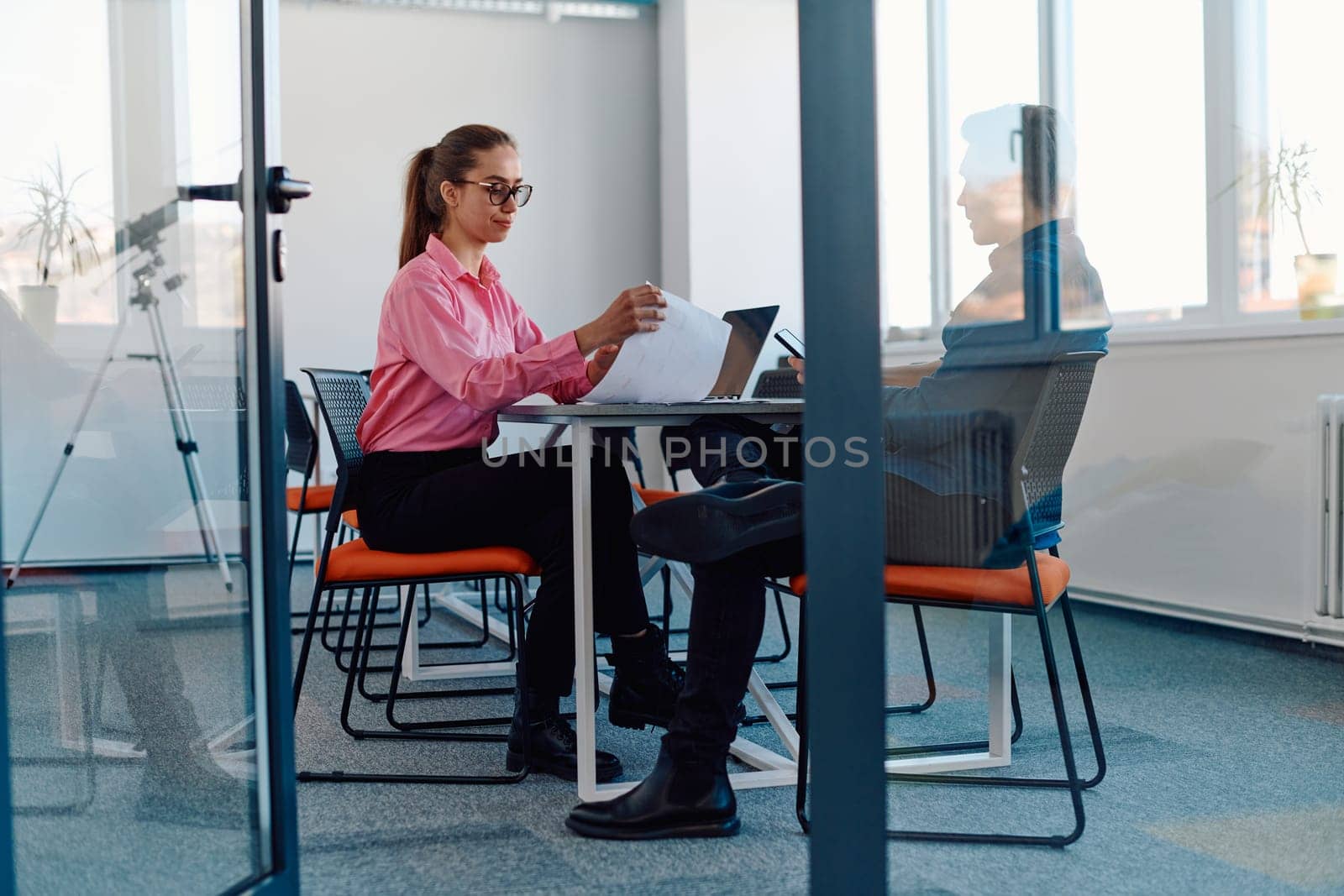 In a sleek, modern glass office, the director engages in a productive discussion with an employee, focusing on business projects and fostering collaboration by dotshock