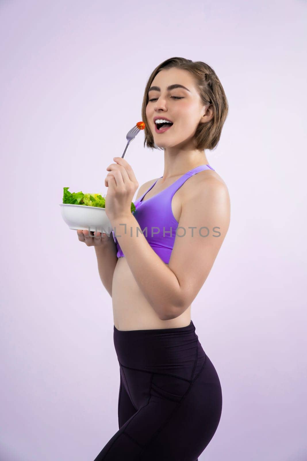 Full body length gaiety shot athletic and sporty young woman with healthy vegan food in standing posture on isolated background. Healthy active and body care by vegetarian lifestyle.