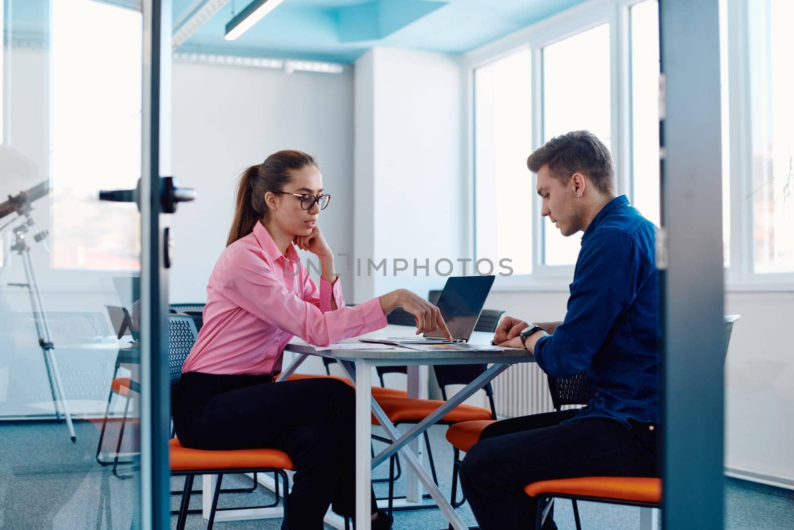 In a sleek, modern glass office, the director engages in a productive discussion with an employee, focusing on business projects and fostering collaboration by dotshock