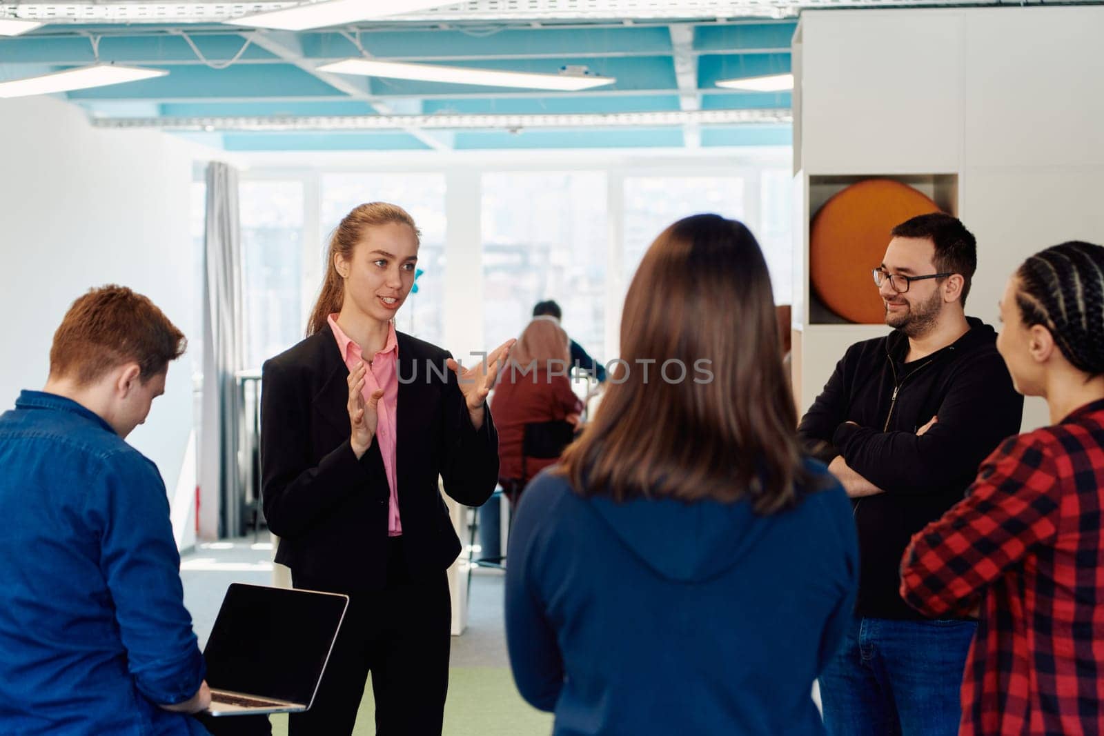 A diverse team of young business people exchanging ideas in a modern startup office.
