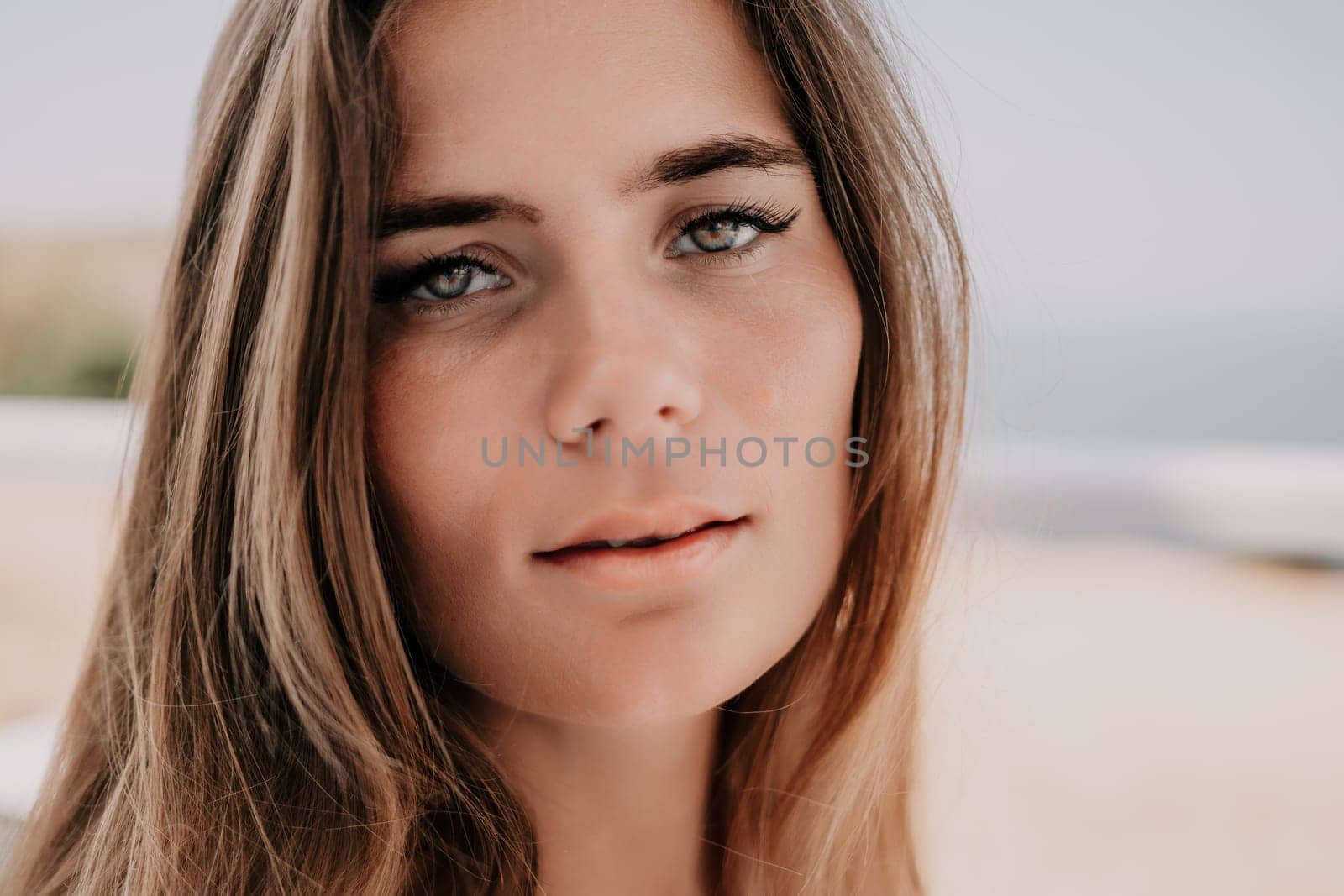 Happy woman portrait in cafe. Boho chic fashion style. Outdoor photo of young happy woman with long hair, sunny weather outdoors sitting in modern cafe