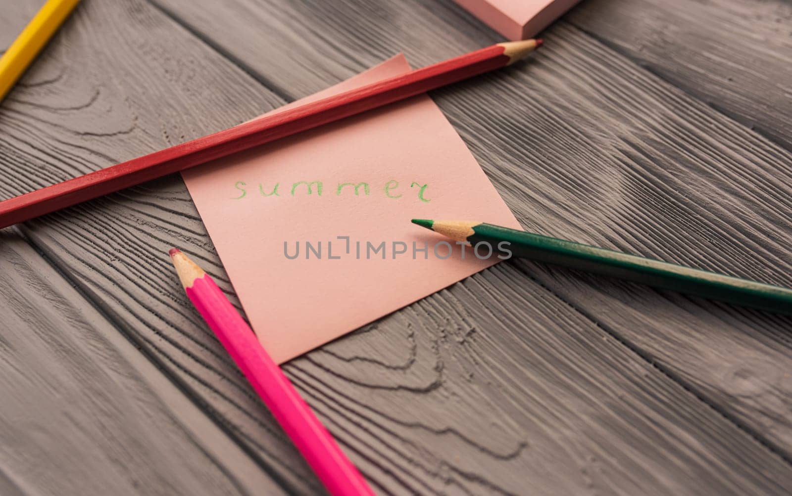 artist multicolored pencils sketch paper card inscription summer. Yellow red blue pencils. Summer background template mockup space blank colorful composition text. Top view above wooden background