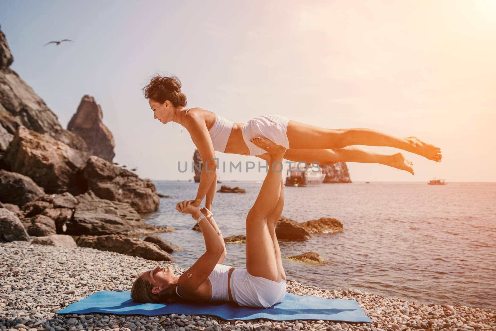 Woman sea yoga. Back view of free calm happy satisfied woman with long hair standing on top rock with yoga position against of sky by the sea. Healthy lifestyle outdoors in nature, fitness concept.